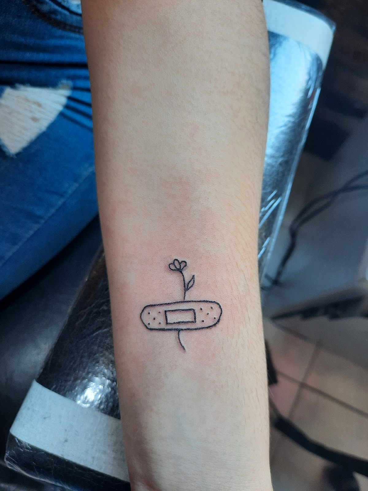 Tatuaje de curita con flor realizado en Lol tattoo